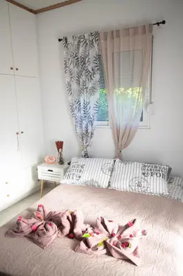 a bedroom with a bed with pink blankets on it at Livadi house in Theologos