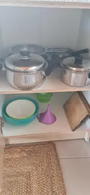 a shelf with pots and pans and plates on it at Livadi house in Theologos