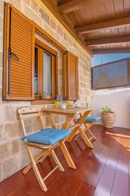 a wooden table and chairs on a patio at Margaritis Luxury Medieval House in Rhodes Town