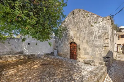 an old stone building with a red door at Margaritis Luxury Medieval House in Rhodes Town