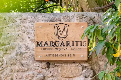 a sign for marragits university hospital house on a stone wall at Margaritis Luxury Medieval House in Rhodes Town
