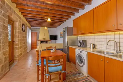 a kitchen with a table and a sink and a dishwasher at Margaritis Luxury Medieval House in Rhodes Town