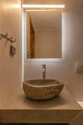 a bathroom with a stone sink and a mirror at Margaritis Luxury Medieval House in Rhodes Town
