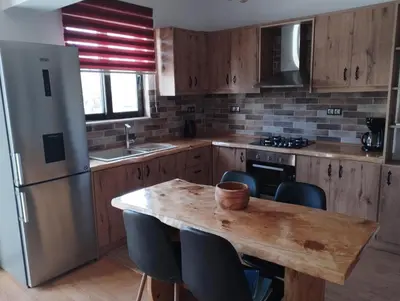 a kitchen with a wooden table and a refrigerator at Olivelia in Ixia