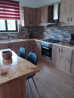 a kitchen with wooden cabinets and a wooden table with chairs at Olivelia in Ixia