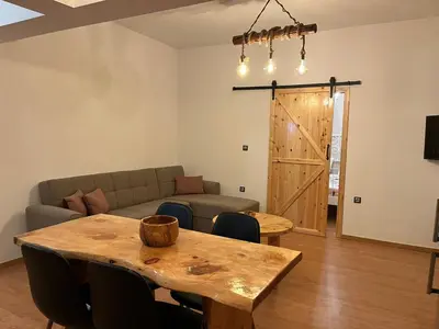 a living room with a wooden table and a couch at Olivelia in Ixia