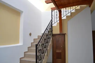 a staircase in a house with a wooden door at Summer Knights in Rhodes Town