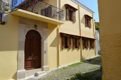 a building with a brown door and a balcony at Summer Knights in Rhodes Town