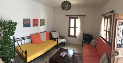 a living room with a yellow couch and a tv at Summer Knights in Rhodes Town