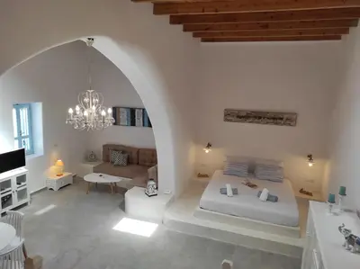 a large white room with a bed and a couch at Traditional Luxury House in Kalithies