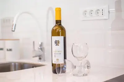 a bottle of wine sitting next to two wine glasses at Traditional Luxury House in Kalithies