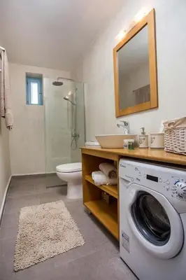 a bathroom with a washing machine and a sink at Traditional Luxury House in Kalithies