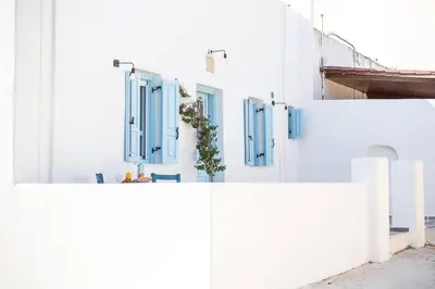 a row of white buildings with blue shuttered windows at Traditional Luxury House in Kalithies