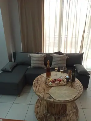 a living room with a couch and a table with wine glasses at Kypseli studio rhodes in Kremasti