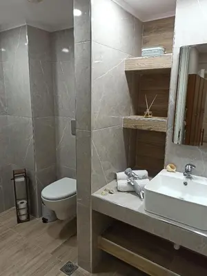 a bathroom with a sink and a toilet and a mirror at Kypseli studio rhodes in Kremasti