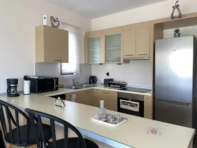 a kitchen with a refrigerator and a table with chairs at Luxury Rhodian Panorama in Ixia