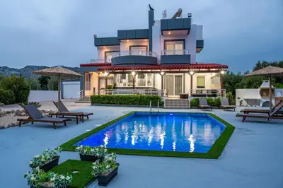 a house with a swimming pool in front of a house at Villa Di Georgia in Afantou