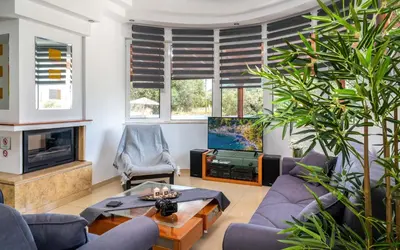 a living room with a couch and a tv at Villa Di Georgia in Afantou