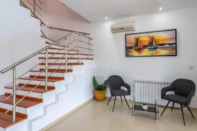 a staircase in a home with two chairs and a painting at Villa Di Georgia in Afantou