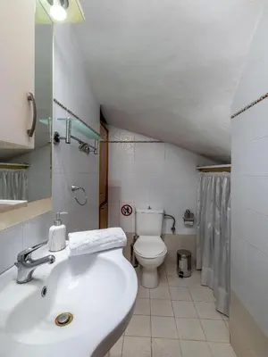 a white bathroom with a sink and a toilet at Villa Di Georgia in Afantou