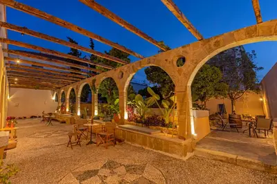 an outdoor patio with arches and tables and chairs at Sala Historical Luxury Suites in Rhodes Town