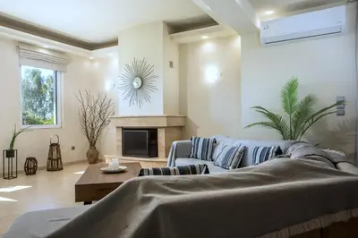 a living room with a couch and a fireplace at Summer Dream Villa in Afantou