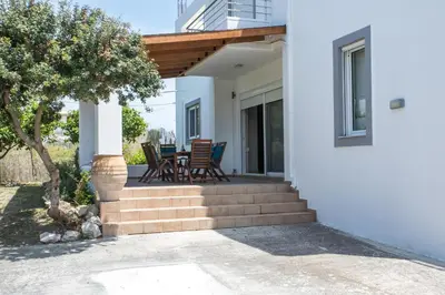 a porch with chairs and a table on a house at Summer Dream Villa in Afantou