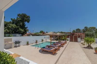 a swimming pool with chaise lounge chairs and a pool at Summer Dream Villa in Afantou