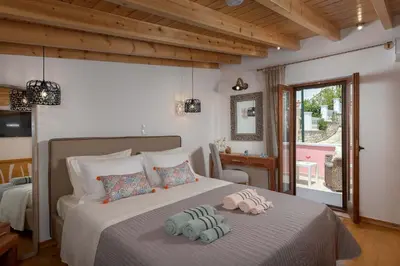 a bedroom with a bed with two towels on it at Captain's Memories Stylish Harbour Apartments in Halki