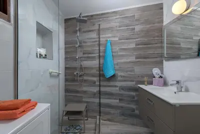 a bathroom with a shower and a toilet and a sink at Captain's Memories Stylish Harbour Apartments in Halki