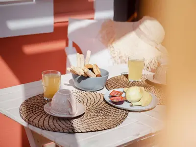 a table with two plates of food and two glasses of orange juice at Captain's Memories Stylish Harbour Apartments in Halki