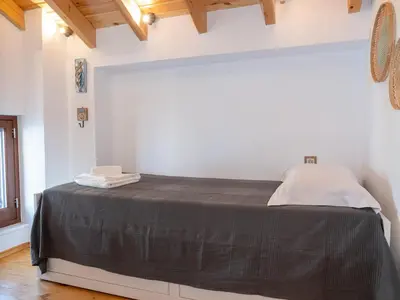 a white room with a bed with a black blanket at Captain's Memories Stylish Harbour Apartments in Halki