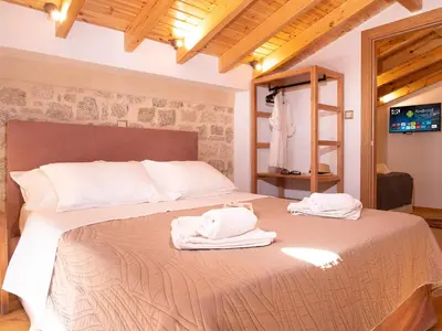a bedroom with a bed with towels on it at Captain's Memories Stylish Harbour Apartments in Halki