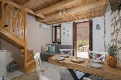 a living room with a table and a couch at Captain's Memories Stylish Harbour Apartments in Halki
