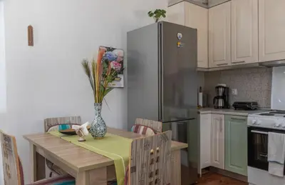 a kitchen with a table with a vase of flowers on it at Ornella's & Laura's secret place in Livadia