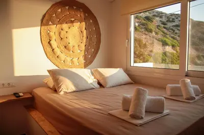 a bedroom with a bed with a large window at Stegna Sunny Beach- up floor in Archangelos