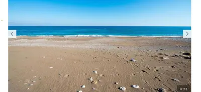 a beach with rocks in the sand and the ocean at Stegna Sunny Beach- up floor in Archangelos