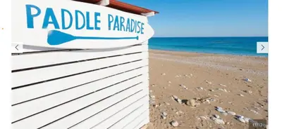 a sign on a beach next to the ocean at Stegna Sunny Beach- up floor in Archangelos