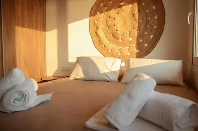 a bedroom with a bed with towels on it at Stegna Sunny Beach- up floor in Archangelos