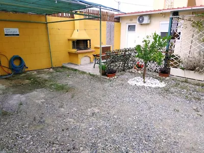a backyard with a stove in a yellow building at Casa Georgia in Faliraki