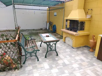 a patio with two benches and a table and a stove at Casa Georgia in Faliraki