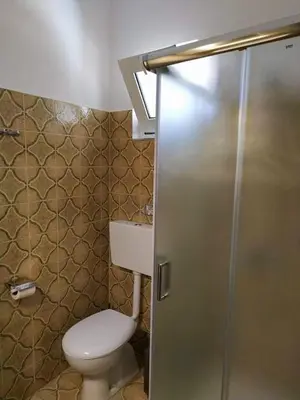 a bathroom with a toilet and a shower stall at Casa Georgia in Faliraki