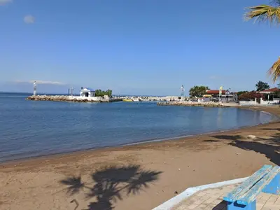 a beach with a blue bench on the shore at Casa Georgia in Faliraki