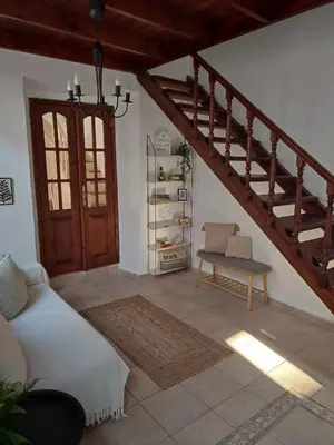 a living room with a staircase and a couch and a chair at Old Town Maisonette in Rhodes Town