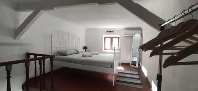 a white bedroom with a bed and a window at Old Town Maisonette in Rhodes Town