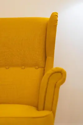 a yellow chair sitting next to a white wall at Kamelia Apartment in Rhodes Town
