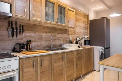 a kitchen with wooden cabinets and a refrigerator at Kamelia Apartment in Rhodes Town
