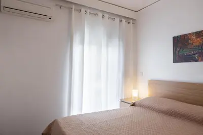 a bedroom with a bed and a large window at Kamelia Apartment in Rhodes Town