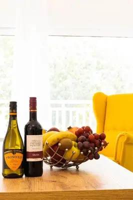 two bottles of wine and a basket of fruit on a table at Kamelia Apartment in Rhodes Town