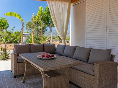 a couch and a table on a patio at G & M Beach House in Haraki